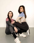 Two models wearing different coloured base layers and leggings.