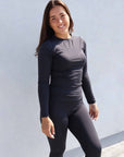Brunette model wearing long sleeve equestrian lycra base layer top
