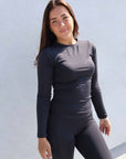 Brunette model wearing long sleeve equestrian lycra base layer top