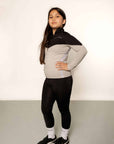 Young rider aged 10 wearing black riding leggings and black and grey tip