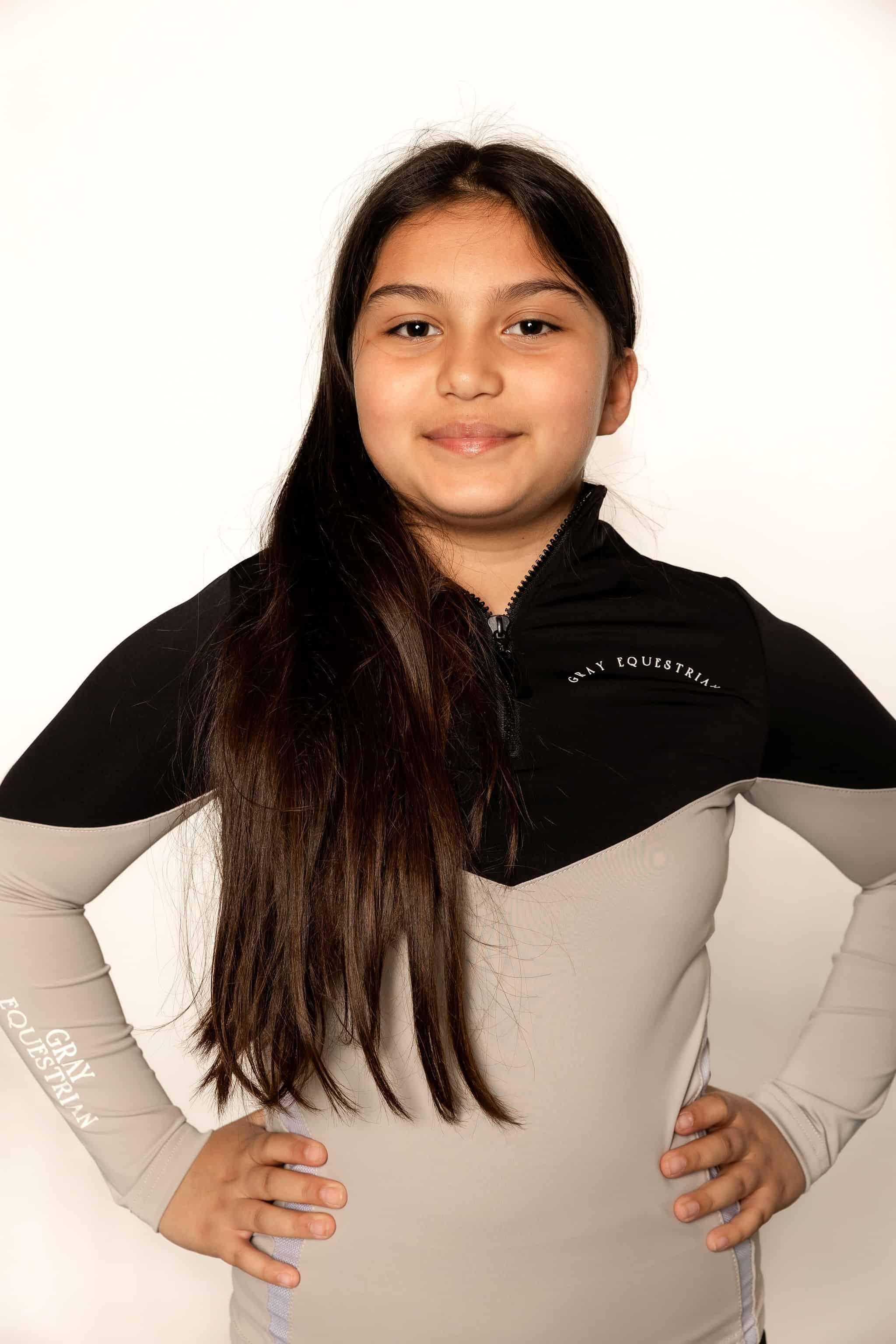 Our child model wearing our black and grey two toned base layer and black riding leggings.
