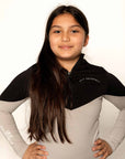 Our child model wearing our black and grey two toned base layer and black riding leggings.