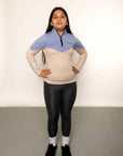 Young rider aged 12 wearing blue and beige base layer with black leggings
