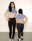 Adult rider and child rider wearing blue and beige base layers with leggings