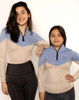 Young rider and adult model wearing beige and blue base layer and riding leggings