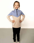 Young rider aged 7 wearing blue and beige base layer with black leggings