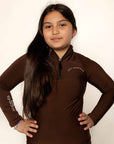 Young child rider wearing brown fleece lined base layer for horse riders.