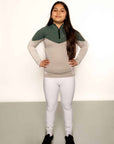 A child model wearing our our green and grey base layer with white leggings.