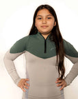A child model wearing our our green and grey base layer with green leggings.