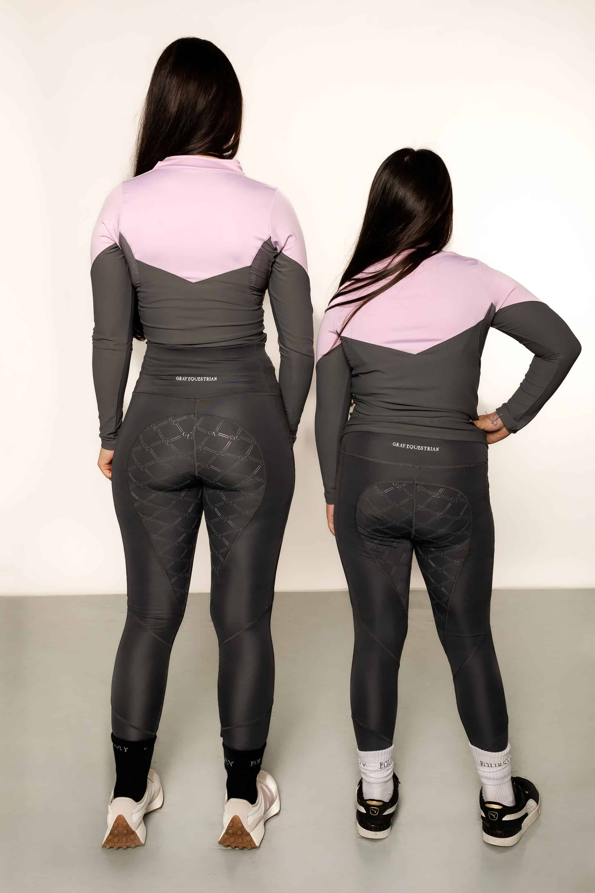 Young rider wearing lilac and grey base layer and grey leggings from behind