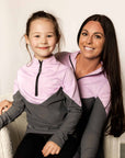 Young rider wearing lilac and grey base layer with adult rider