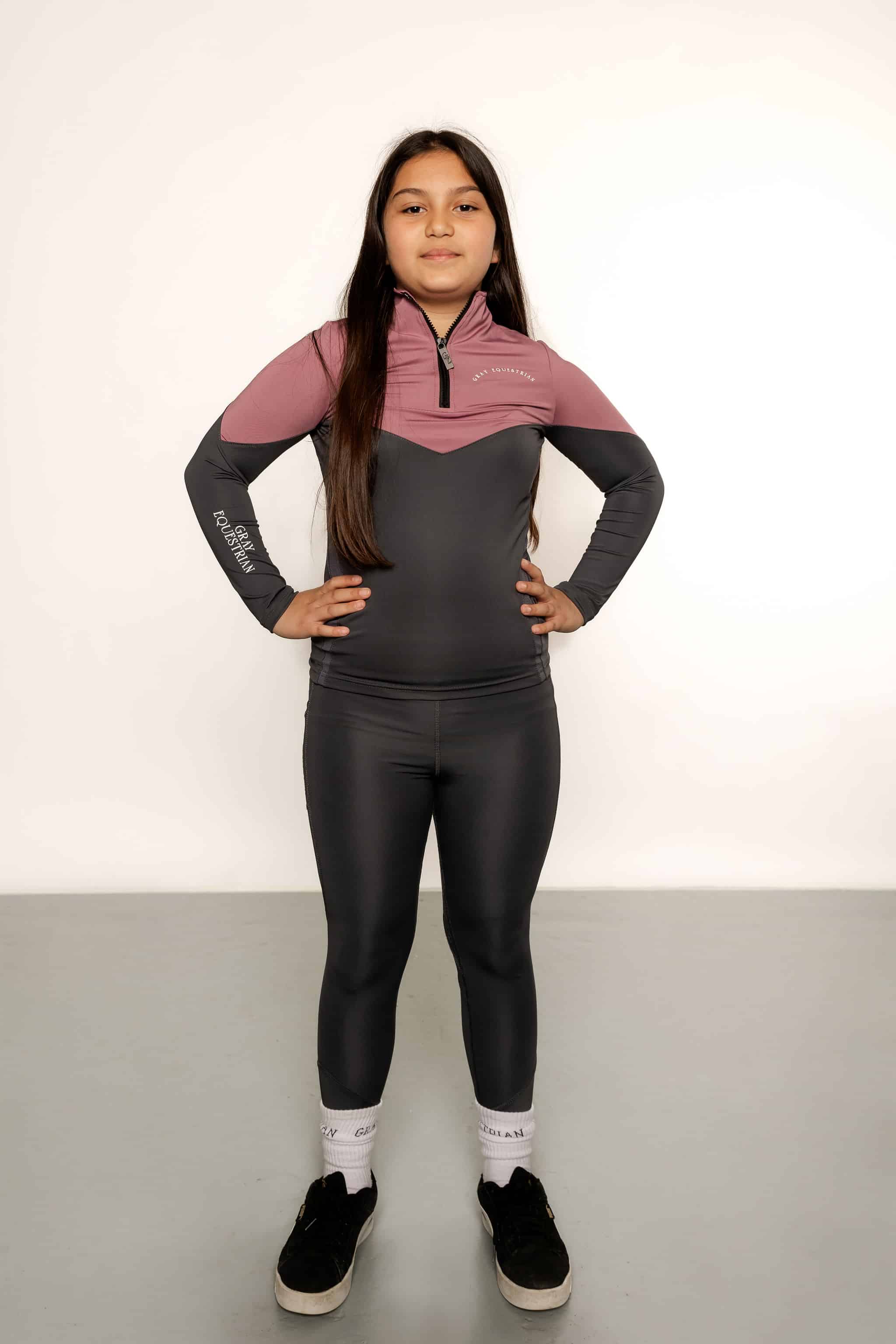 Young rider wearing grey and pink base layer and grey leggings
