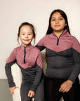 Two young riders wearing grey and pink base layers