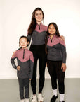 2 young riders with an adult rider all matching in pink and grey