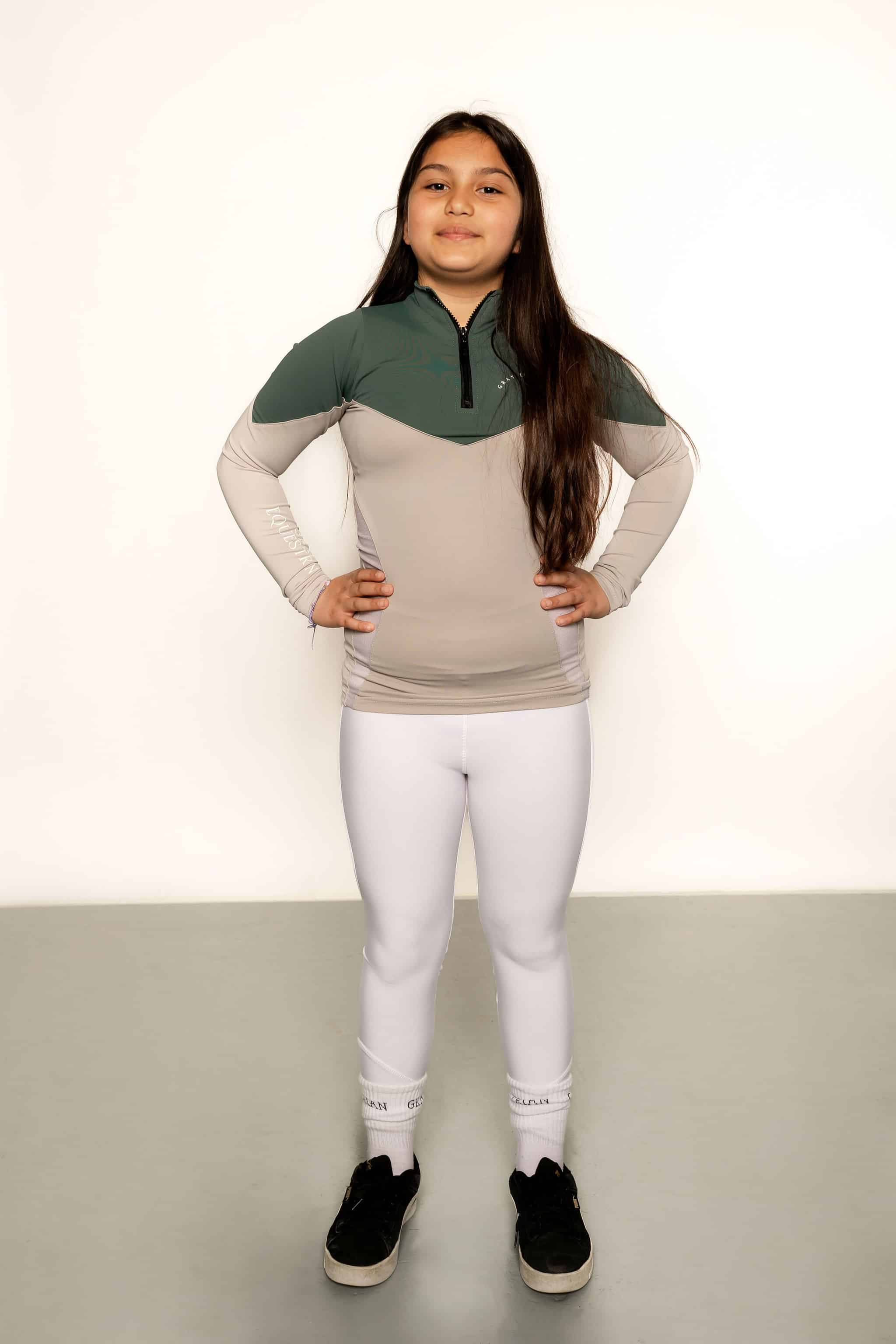 Young rider children white competition leggings whilst riding.