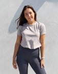 Brunette model wearing grey cotton t shirt with charcoal grey leggings.