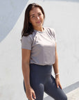 Brunette model wearing grey cotton t shirt with charcoal grey leggings.