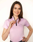 Brunette model wearing lilac short sleeved equestrian base layer with black 1/4 zip