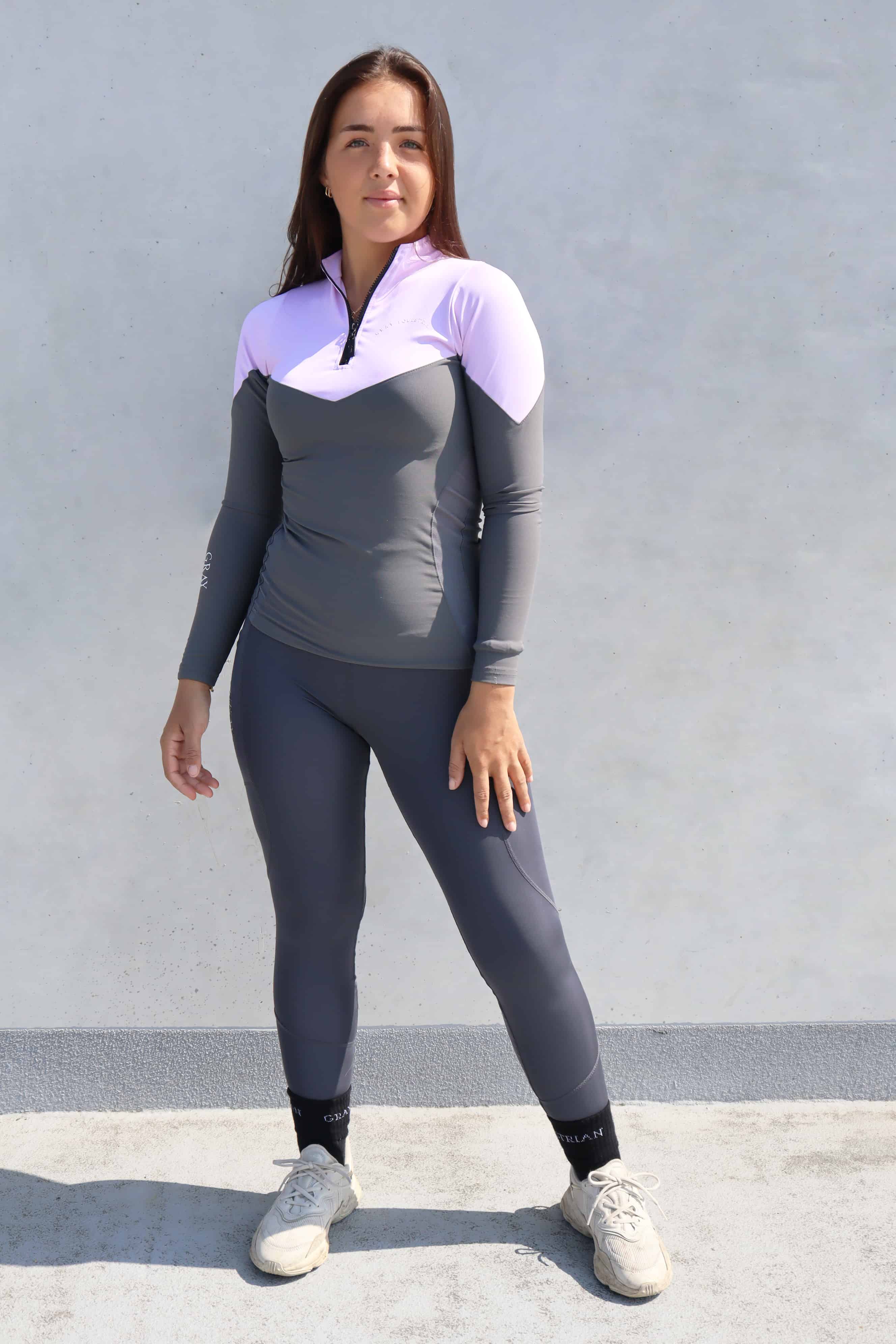 Equestrian rider  wearing the lilac and grey base layer top and grey leggings