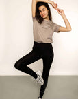 Brunette model wearing cotton grey t shirt and black riding leggings