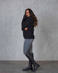 Brunette model wearing our black fleece-lined oversized equestrian hoodie and grey riding leggings.