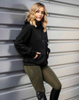 Blonde model wearing our black fleece-lined oversized equestrian hoodie and grey riding leggings.
