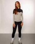 Red haired model wearing our long-sleeved black and grey two toned base layer and black equestrian leggings.