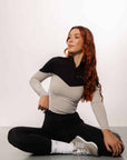 Red haired model wearing our long-sleeved black and grey two toned base layer and black equestrian leggings.