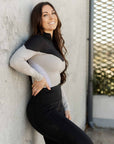 Brunette model wearing our long-sleeved black and grey two toned base layer.