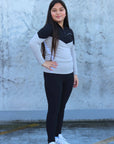 Our child model wearing our black and grey two toned base layer and black riding leggings.