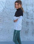 Our child model wearing our black and grey two toned base layer and green riding leggings.