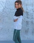 A child model wearing our green renew riding leggings.