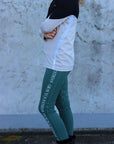 A child model wearing our green renew riding leggings.
