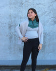 A child model wearing our our green and grey base layer with black leggings.