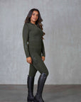 A brunette model wearing our fleece lined long sleeve khaki base layer and matching khaki riding leggings.