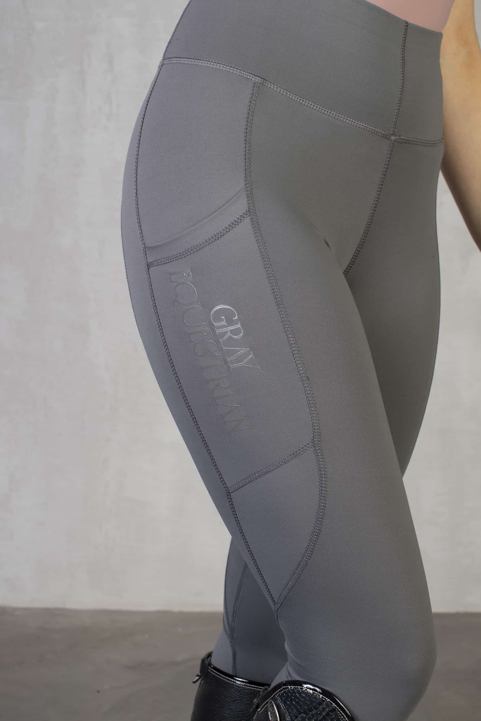 A view of the side of our grey riding leggings with phone pocket.