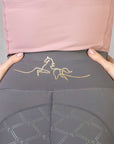 A view of the minimal gold horse detailing on the back waistband of our grey leggings.