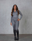 A brunette model wearing our long sleeved grey two toned base layer with matching riding leggings.