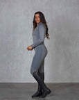 A brunette model wearing our long sleeved grey two toned base layer with matching riding leggings.