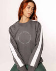 A model wearing our grey sweatshirt with white paneling down the sleeves and minimalist Grey Equestrian branding.