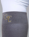 A close up of the gold G E logo on the top of our grey equestrian socks.