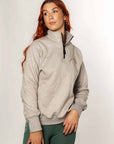 A model wearing our taupe grey 1/4 zip sweatshirt and green riding leggings.