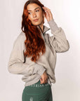 A model wearing our taupe grey 1/4 zip sweatshirt and green riding leggings.