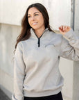 A model wearing our taupe grey 1/4 zip sweatshirt and black riding leggings.