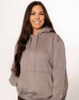 A model wearing our taupe grey hoodie and brown riding leggings.