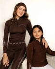 Young rider and adult rider wearing brown fleece lined base layer for horse riders.