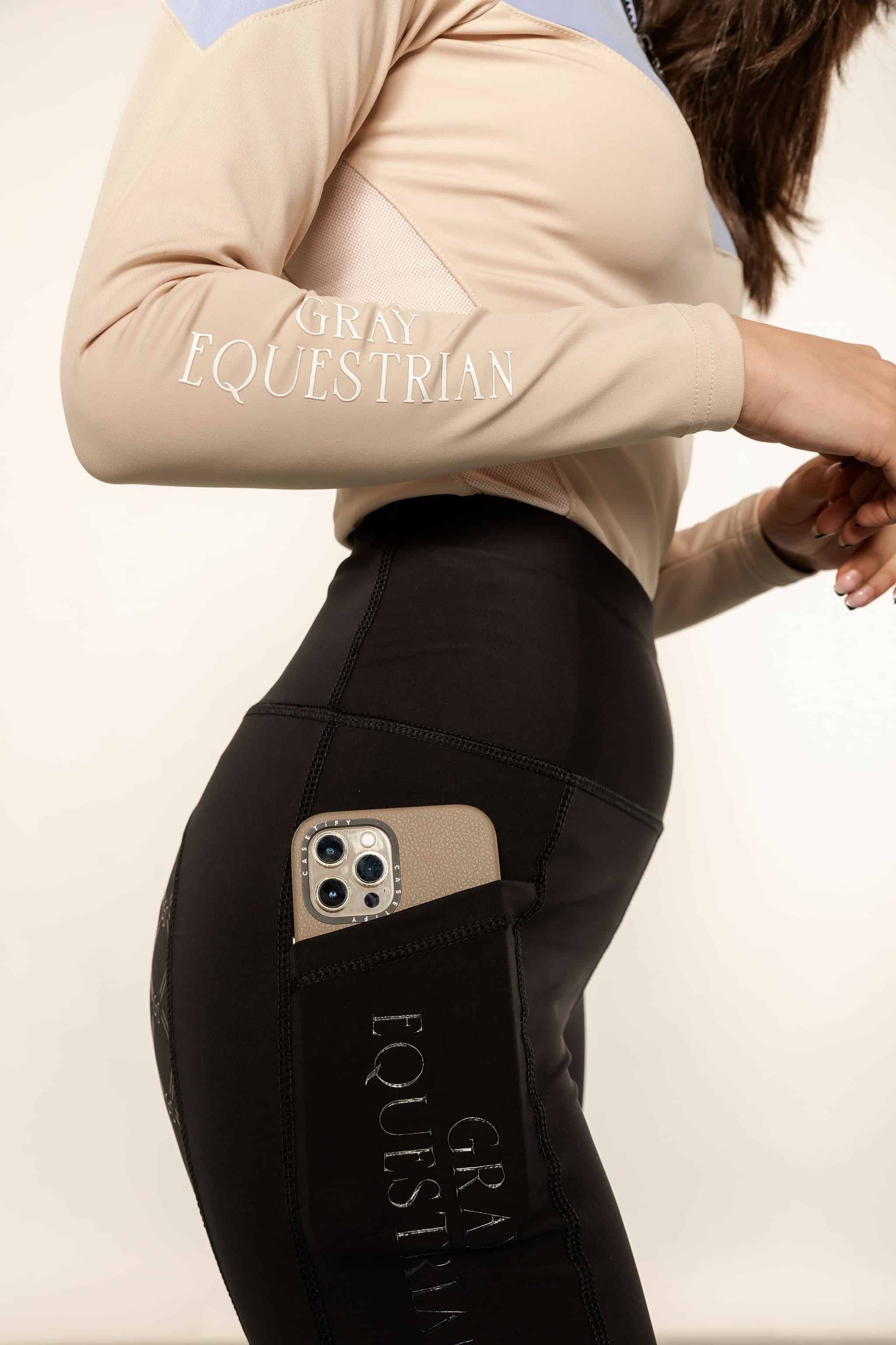 Close up of details on blue and beige base layer and black leggings with full size phone pocket