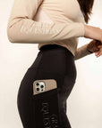 Close up of details on blue and beige base layer and black leggings with full size phone pocket