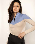 Model wearing a two tone equestrian base layer with 1/4 zip detail and mesh side panels.