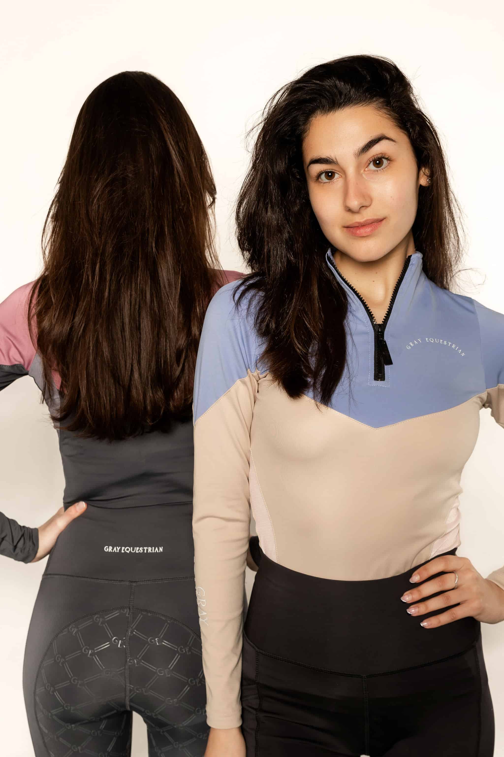 Two models wearing two tone equestrian base layers with 1/4 zip detail and mesh side panels.